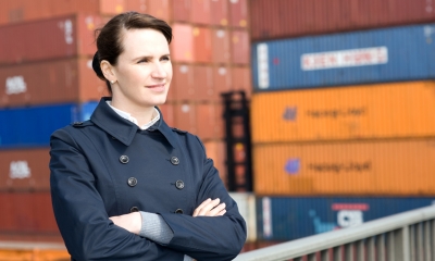 Using agents and distributors Businesswoman against background of shipping containers at distribution hub