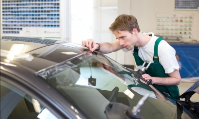 a man repairs a car windscreen