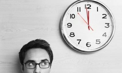 Male employee looking at clock on wall Male employee looking at clock on wall