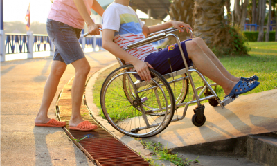Person on a wheelchair being pushed up a platform