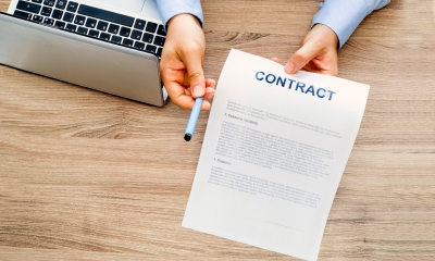 Contract being held out with a pen