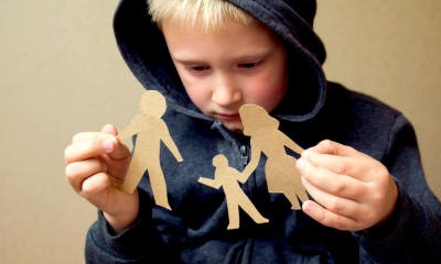 Little boy holding cardboard cutouts of his family