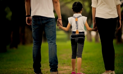 Divorce and children Young child walking between her parents holding hands