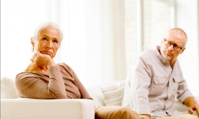 Older couple sitting on a sofa contemplating a divorce