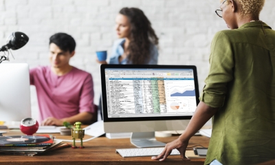 An office worker processes a spreadsheet of customer details - data protection concept.