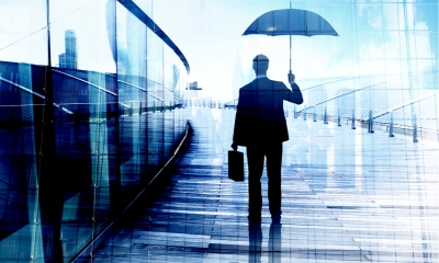 Businessman Standing While Holding an Umbrella Businessman Standing While Holding an Umbrella