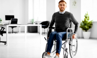Young man in wheelchair at workplace Young man in wheelchair at workplace