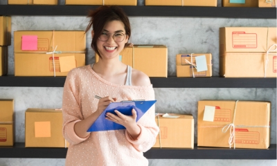 A new entrepreneur in her new logistics factory holding a checkboard