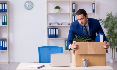 Employee putting all of his work belongings into a cardboard box