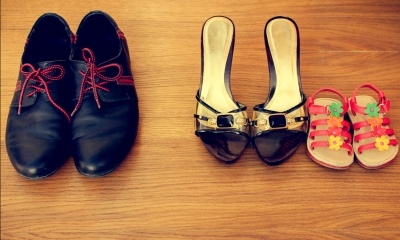 Pair of male shoes lined up next to a pair of female shoes and a child's shoes