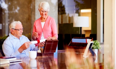 Happy elderly couple looking through documents including their will