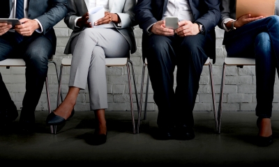 Group of people sat down on chairs holding objects in their hands