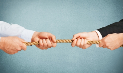 Two businessmen in a tug of war, blue background