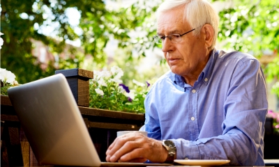 Senior man working with laptop in outdoor cafe Senior man working with laptop in outdoor cafe
